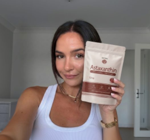 Customer holding up a pouch of Reya Organics Astaxanthin at home