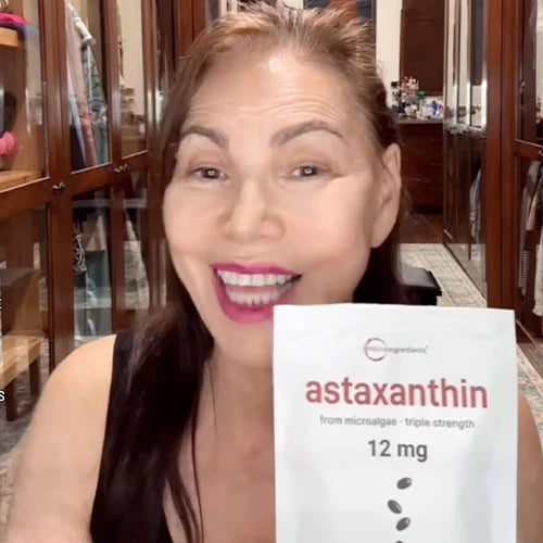 Smiling customer holding up a pouch of triple-strength 12 mg astaxanthin from microalgae